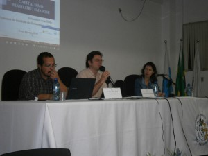 Mesa de abertura da Semana de Economia do IM, com o diretor, professor Alexandre Fortes, o professor Eduardo Costa Pinto e a mediadora, professora Grasiela Baruco