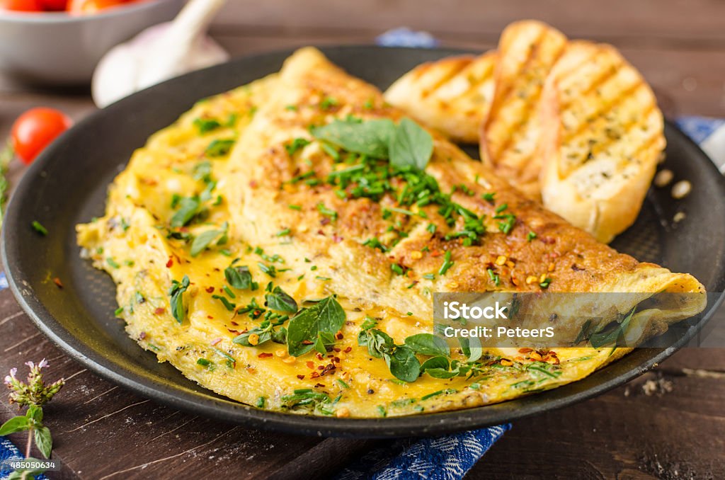 Herb omelette with chives and oregano sprinkled with chili flakes, garlic panini toasts